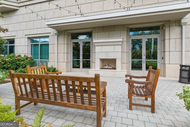 view of patio featuring exterior fireplace and french doors