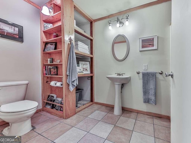 bathroom featuring tile patterned flooring, toilet, and crown molding