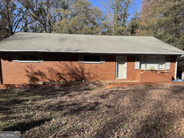 view of front of home featuring a shingled roof and brick siding