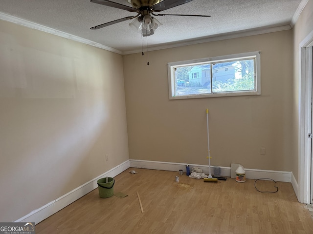 spare room featuring wood finished floors, a textured ceiling, ceiling fan, and crown molding