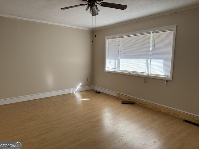 empty room featuring a textured ceiling, visible vents, light wood finished floors, and ceiling fan