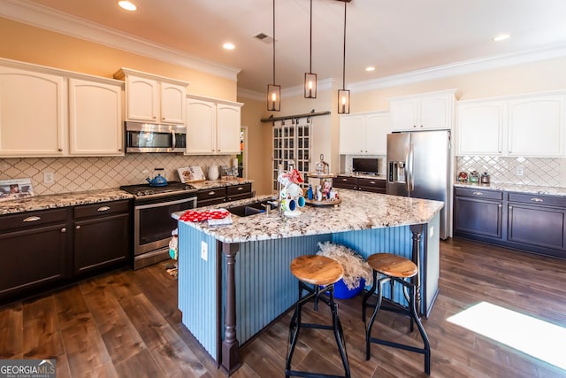 kitchen featuring a center island with sink, dark wood-type flooring, and appliances with stainless steel finishes