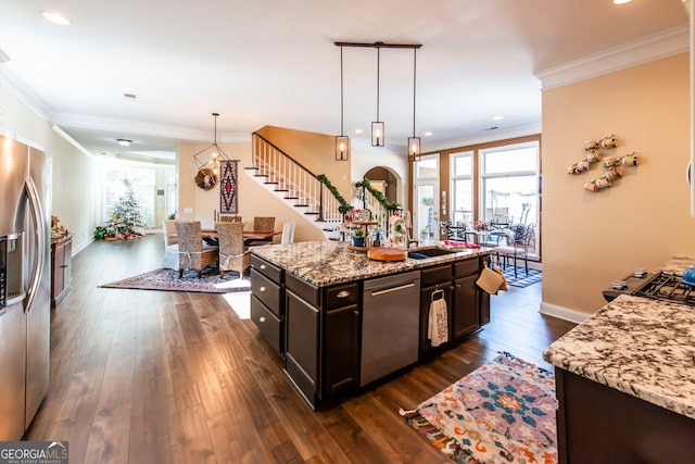 kitchen featuring dark hardwood / wood-style floors, a center island, stainless steel appliances, and hanging light fixtures