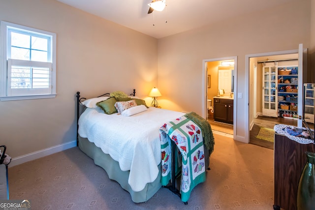 bedroom with ceiling fan, carpet floors, and ensuite bathroom