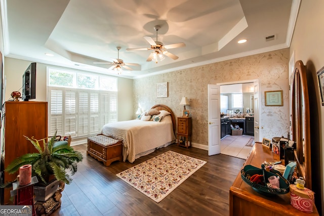 bedroom featuring dark hardwood / wood-style floors, multiple windows, and a tray ceiling