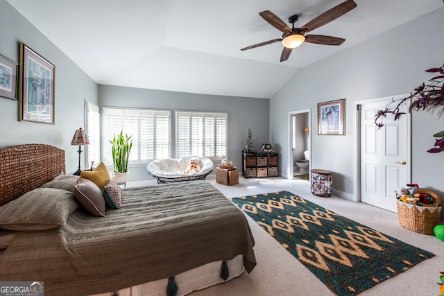 carpeted bedroom featuring ensuite bathroom, vaulted ceiling, and ceiling fan