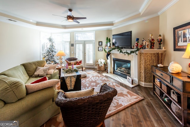 living room with ceiling fan, french doors, dark hardwood / wood-style flooring, a tray ceiling, and ornamental molding