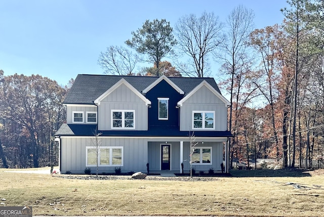 view of property featuring covered porch and a front yard