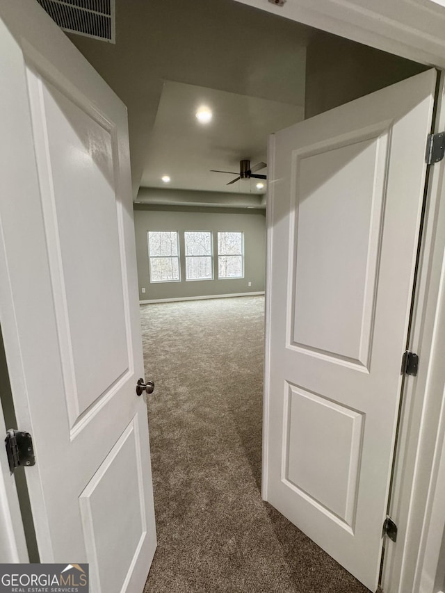 hallway featuring dark colored carpet