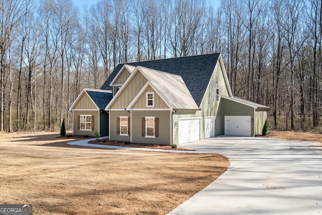 view of front of house featuring board and batten siding, a shingled roof, and a view of trees