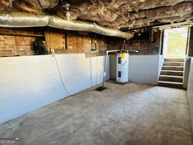 basement featuring brick wall and water heater