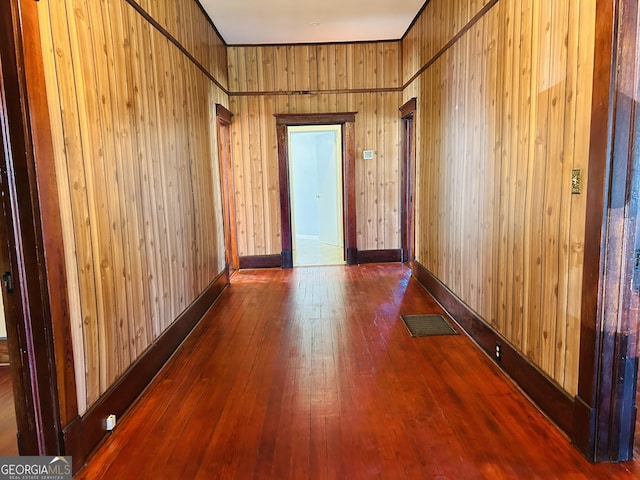 hallway with wood-type flooring and wood walls