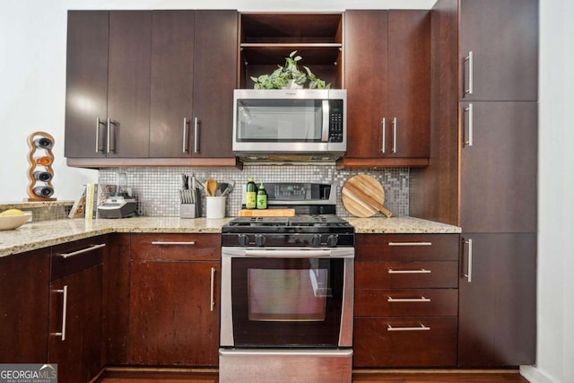 kitchen with decorative backsplash, appliances with stainless steel finishes, light stone counters, and dark brown cabinets