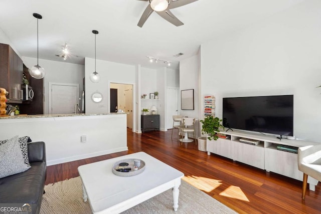 living room featuring ceiling fan and dark hardwood / wood-style floors