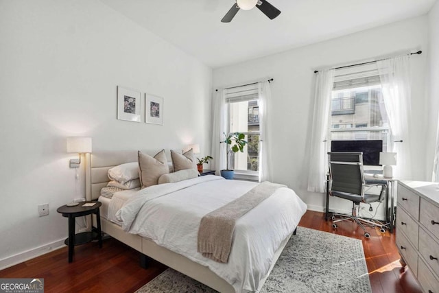 bedroom with ceiling fan, dark wood finished floors, and baseboards