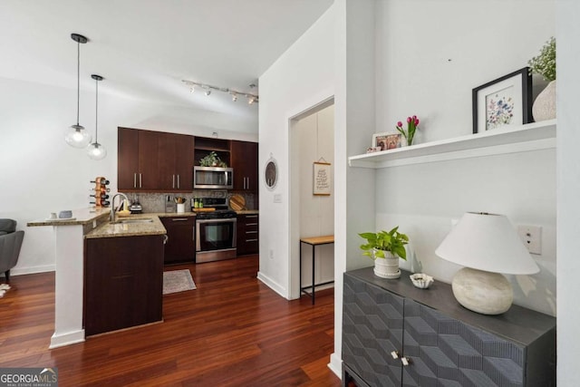 kitchen with sink, appliances with stainless steel finishes, decorative light fixtures, dark hardwood / wood-style flooring, and kitchen peninsula