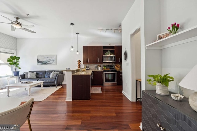 kitchen featuring light stone counters, dark brown cabinetry, appliances with stainless steel finishes, dark wood-style floors, and decorative light fixtures