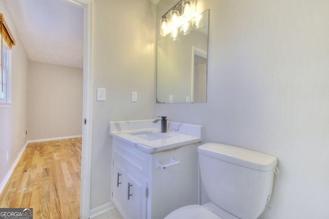 bathroom with vanity, wood-type flooring, a textured ceiling, and toilet