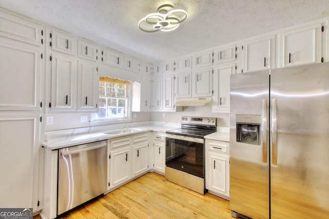 kitchen featuring light hardwood / wood-style floors, white cabinetry, a textured ceiling, and appliances with stainless steel finishes