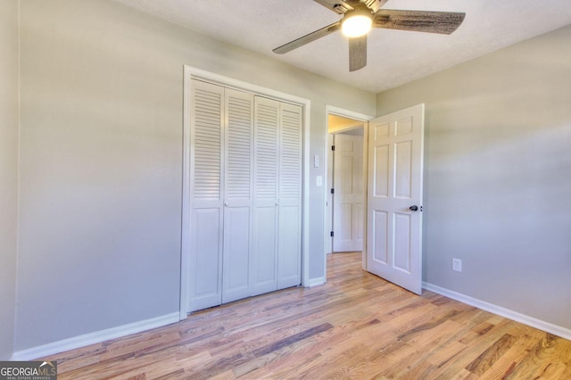 unfurnished bedroom featuring ceiling fan, light hardwood / wood-style floors, a textured ceiling, and a closet