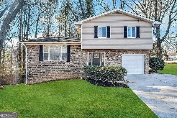 tri-level home with a front lawn and a garage