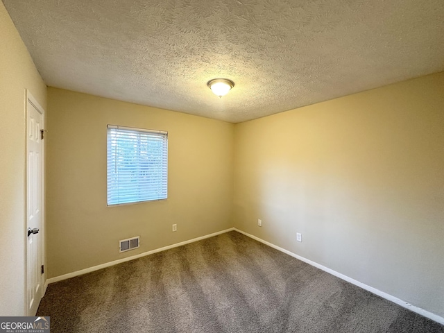 empty room featuring carpet and a textured ceiling