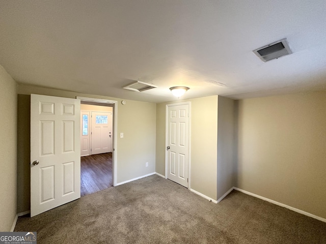 empty room featuring dark colored carpet