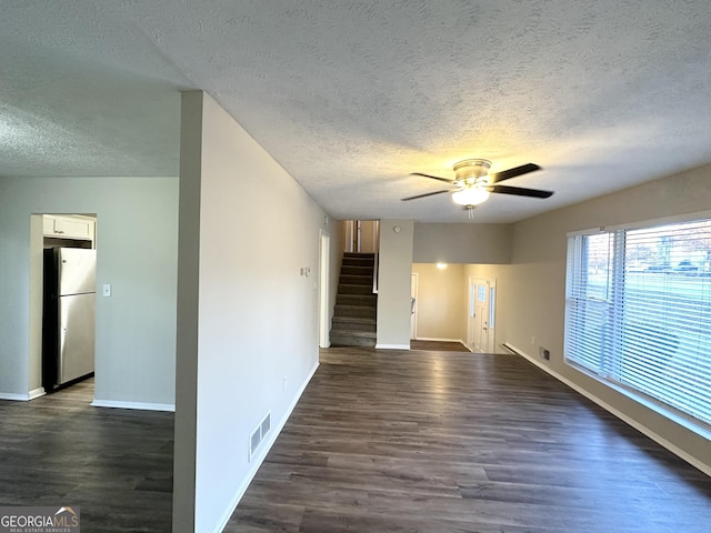 unfurnished room with ceiling fan, dark hardwood / wood-style flooring, and a textured ceiling