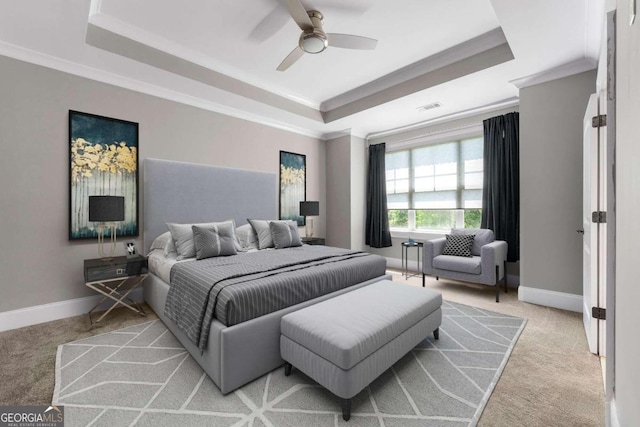 carpeted bedroom featuring a tray ceiling, ceiling fan, and ornamental molding