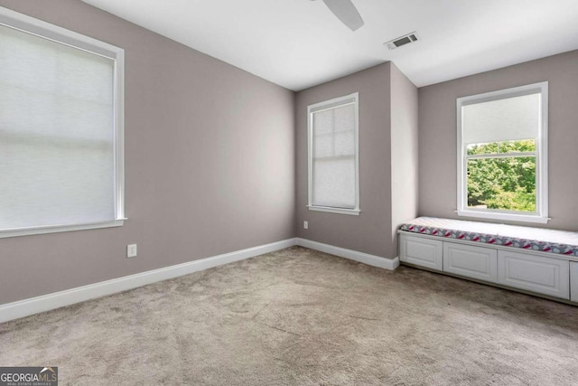 carpeted spare room with ceiling fan