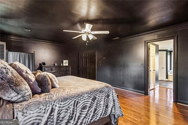 bedroom with ceiling fan, wood-type flooring, and crown molding