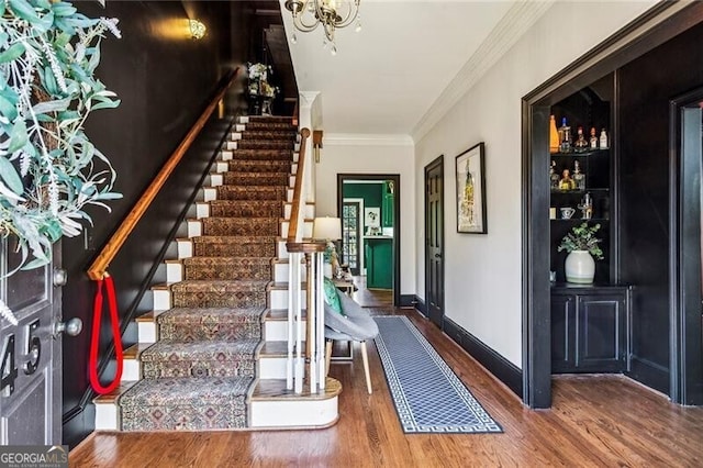 staircase with crown molding and hardwood / wood-style floors