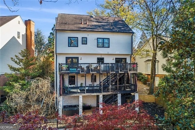 rear view of house featuring a wooden deck and a balcony