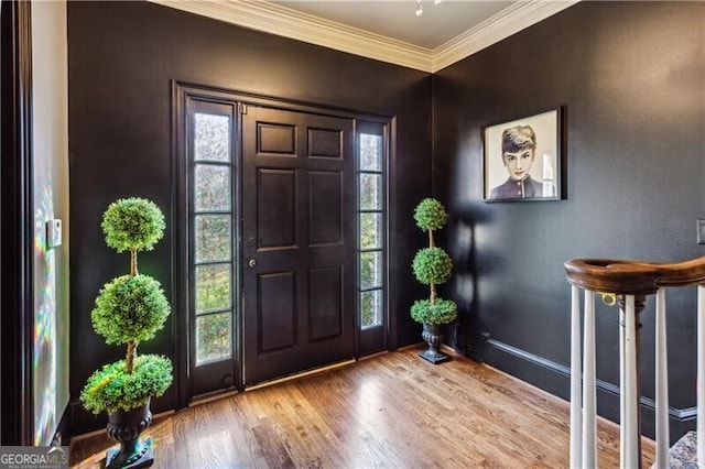 foyer with wood-type flooring and ornamental molding