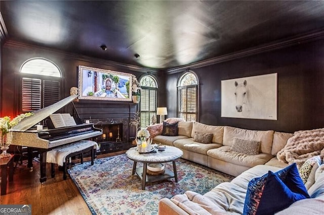 living room with a high end fireplace, ornamental molding, and hardwood / wood-style flooring