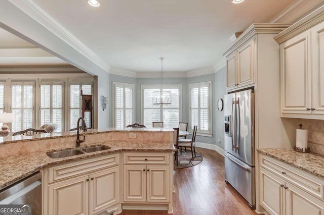 kitchen with hanging light fixtures, a healthy amount of sunlight, sink, and appliances with stainless steel finishes