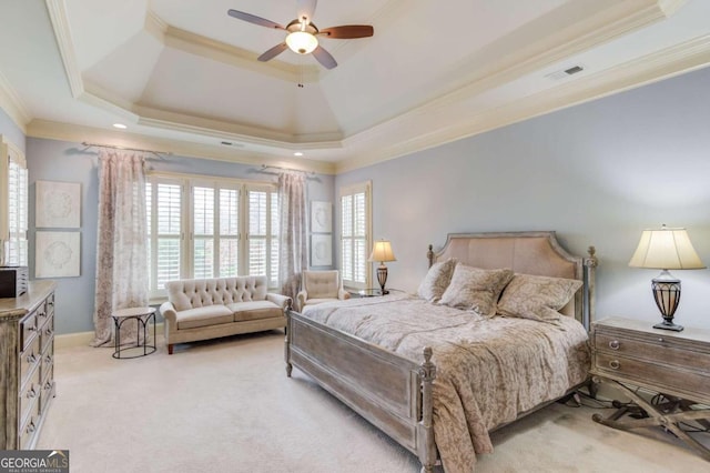 bedroom with a tray ceiling, light carpet, and ornamental molding