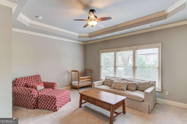 carpeted living room featuring a tray ceiling, ceiling fan, and crown molding