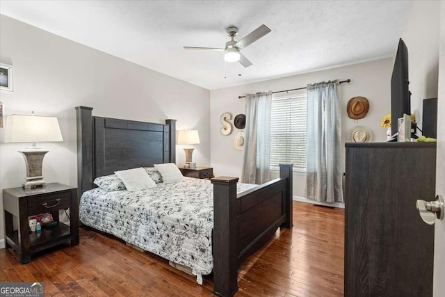 bedroom with dark hardwood / wood-style floors and ceiling fan