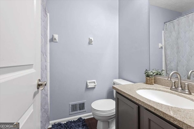 bathroom with hardwood / wood-style floors, vanity, and toilet