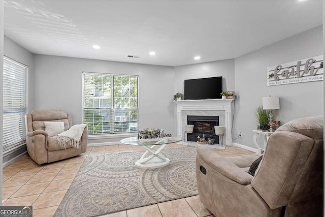 tiled living room featuring a premium fireplace