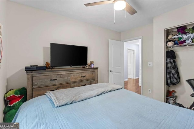 bedroom with wood-type flooring, a closet, and ceiling fan