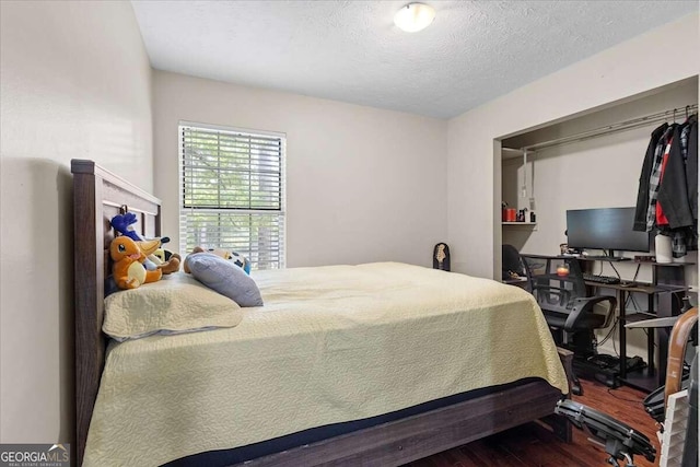 bedroom featuring wood-type flooring and a textured ceiling