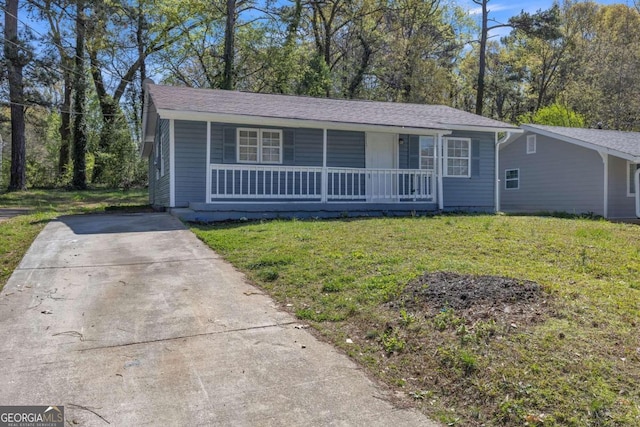 ranch-style house featuring covered porch and a front yard