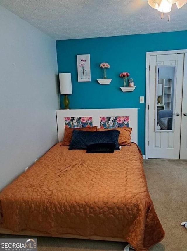 bedroom featuring carpet, ceiling fan, and a textured ceiling