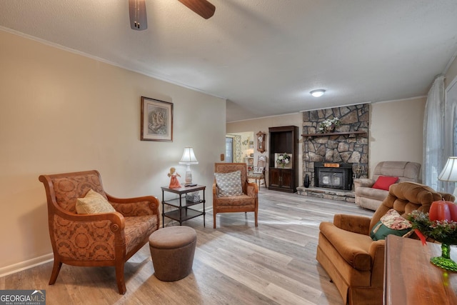 living room featuring ceiling fan, light wood-type flooring, and ornamental molding