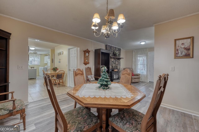 dining space featuring ornamental molding, a notable chandelier, and light wood-type flooring