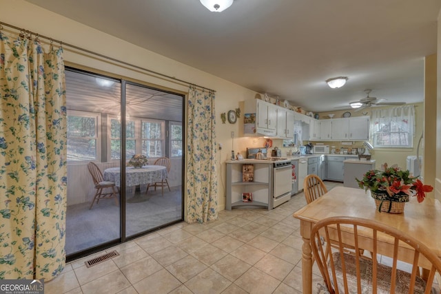 tiled dining room with plenty of natural light and ceiling fan