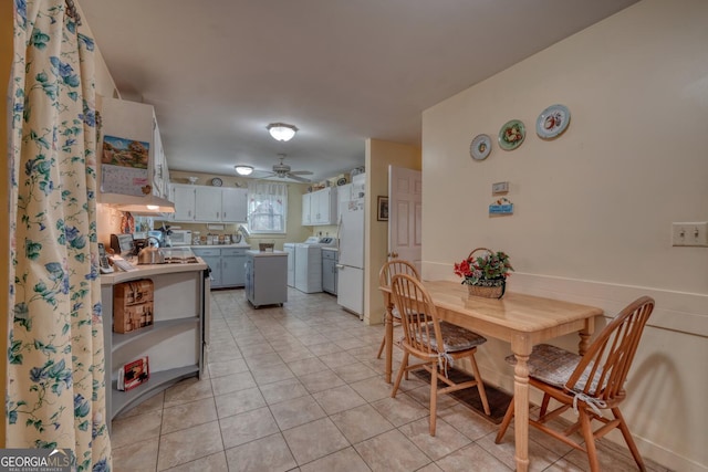 dining space with light tile patterned floors, separate washer and dryer, and ceiling fan