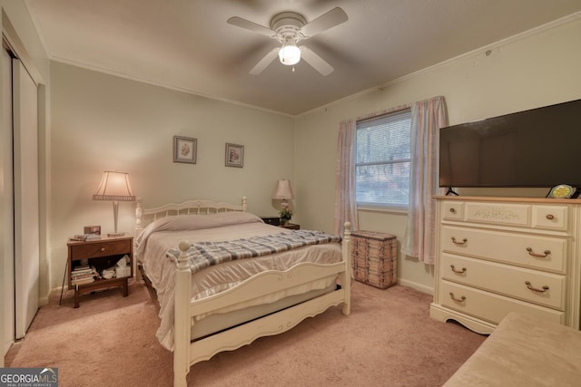 carpeted bedroom featuring ceiling fan, crown molding, and a closet